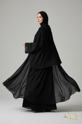 Female model wearing Retro Project Classic Black Abaya on light gray background